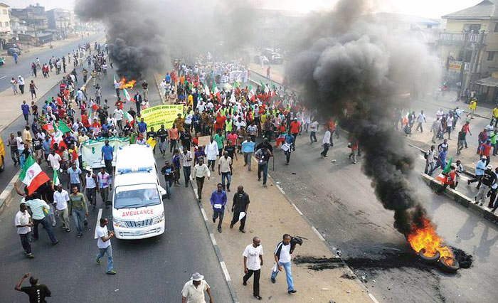 The scene of a 2019 political violence in Nigeria, a crowd protesting in the backdrop of fire and smoke